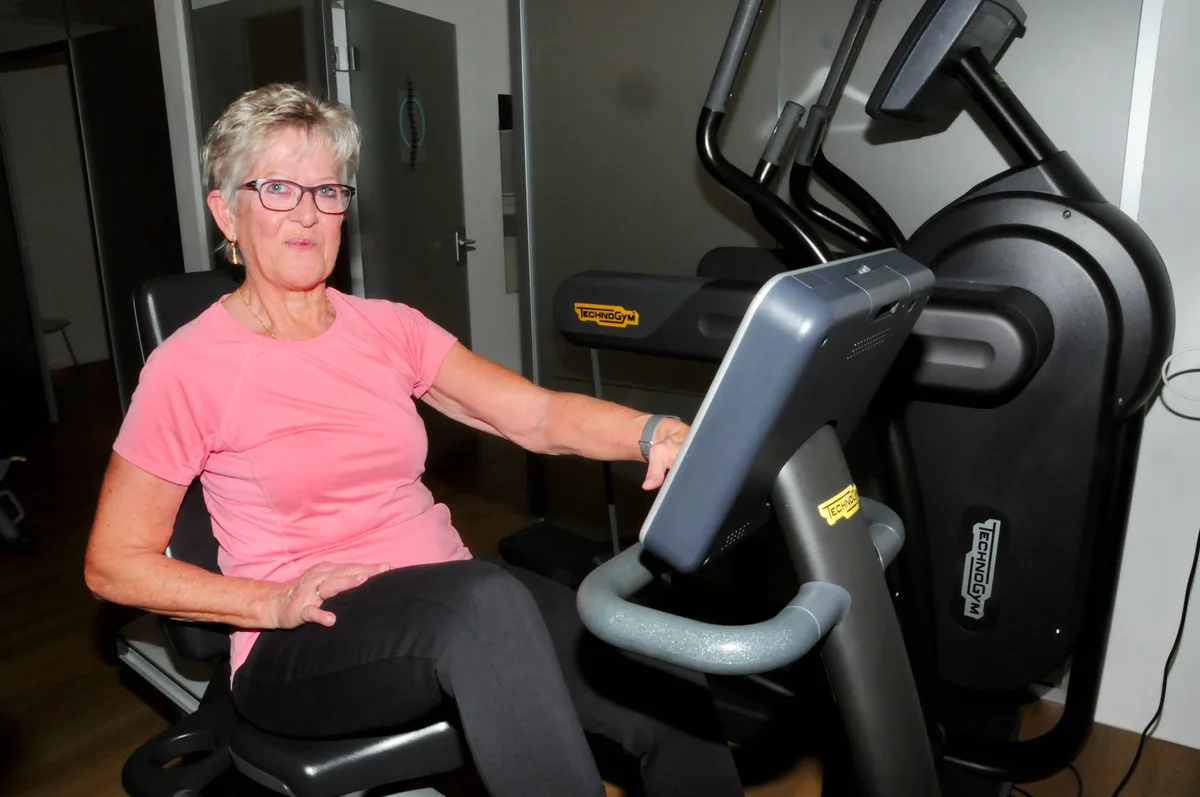 Man sieht eine Frau auf dem Ergometer.
